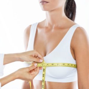 Breast Augmentation Procedure 8 Doctor with measure tape measuring the size of the patients breast.