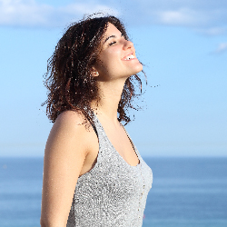 Beautiful girl breathing and smiling on the beach