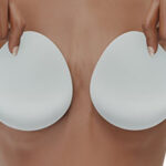 Woman covers her breasts with silicone implants
